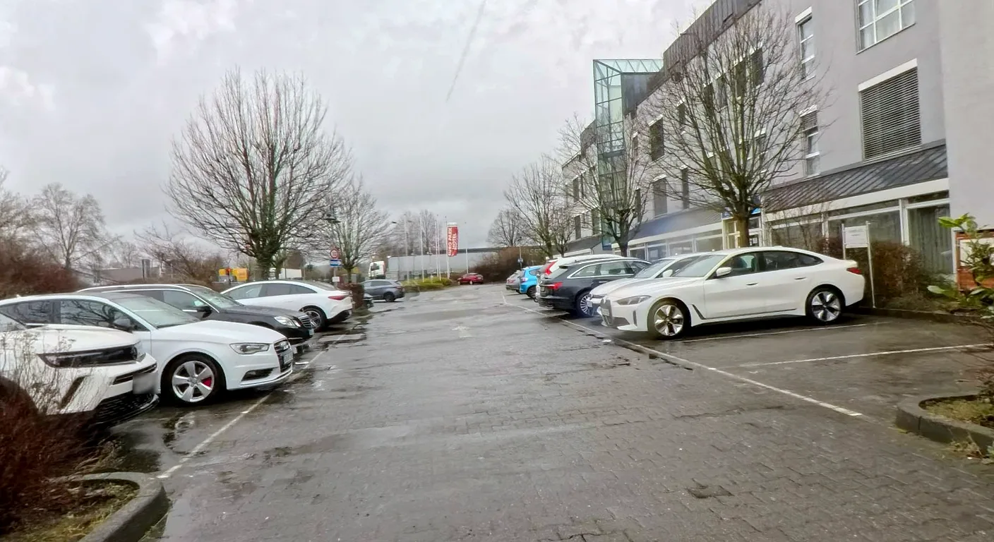Parkplatz direkt am EURO PARK HOTEL Hennef mit Stellplätzen auf beiden Seiten der gepflasterten Zufahrt, aufgenommen an einem Wintertag